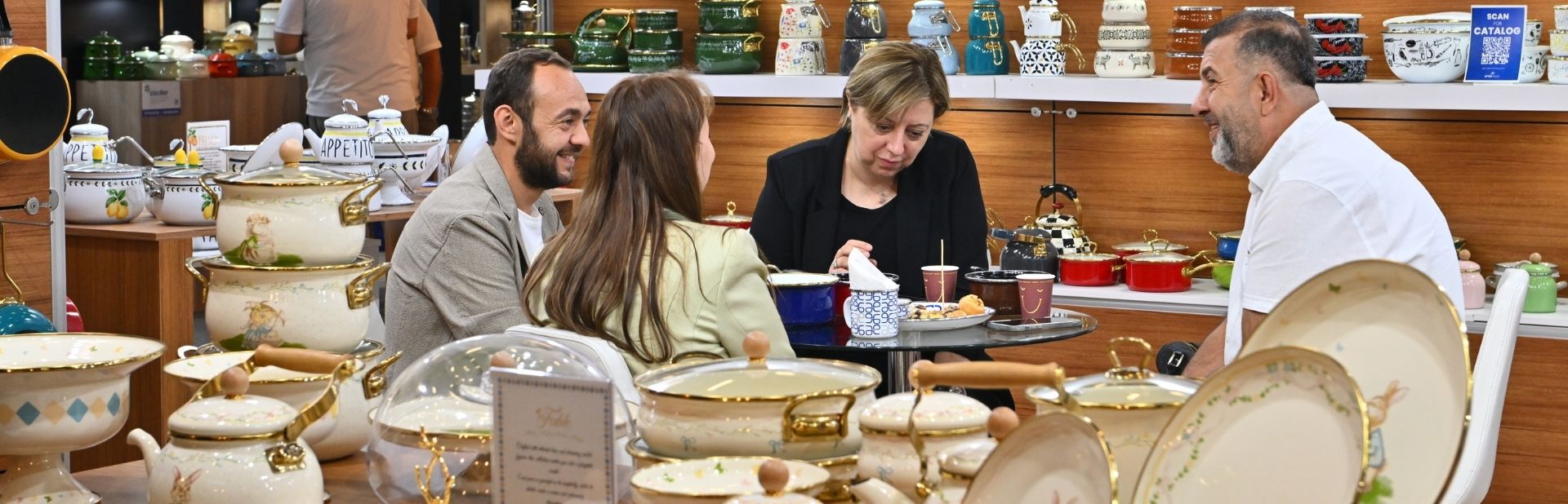 Bir katılımcı ziyaretçilere elektronik mutfak eşyalarını tanıtıyor ve bilgi veriyor.