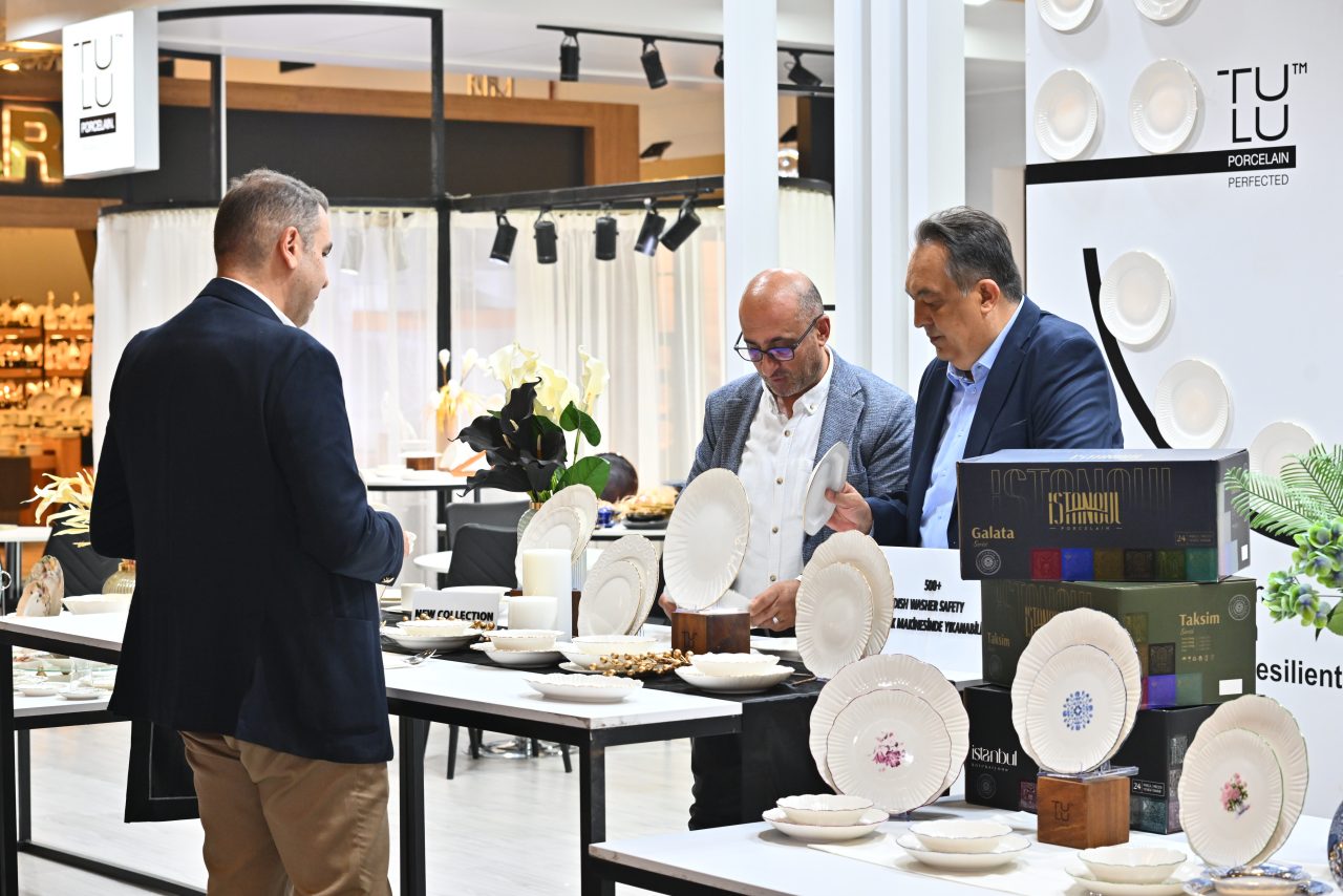 A woman photographed at last year's Zuchex event, featuring visitors interacting with exhibitors and exploring various kitchenware items