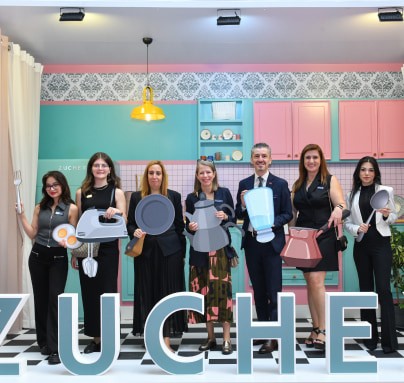 The team poses with mock-up products in the colorful ZUCHEX kitchen designed by the team for this year's ZUCHEX.